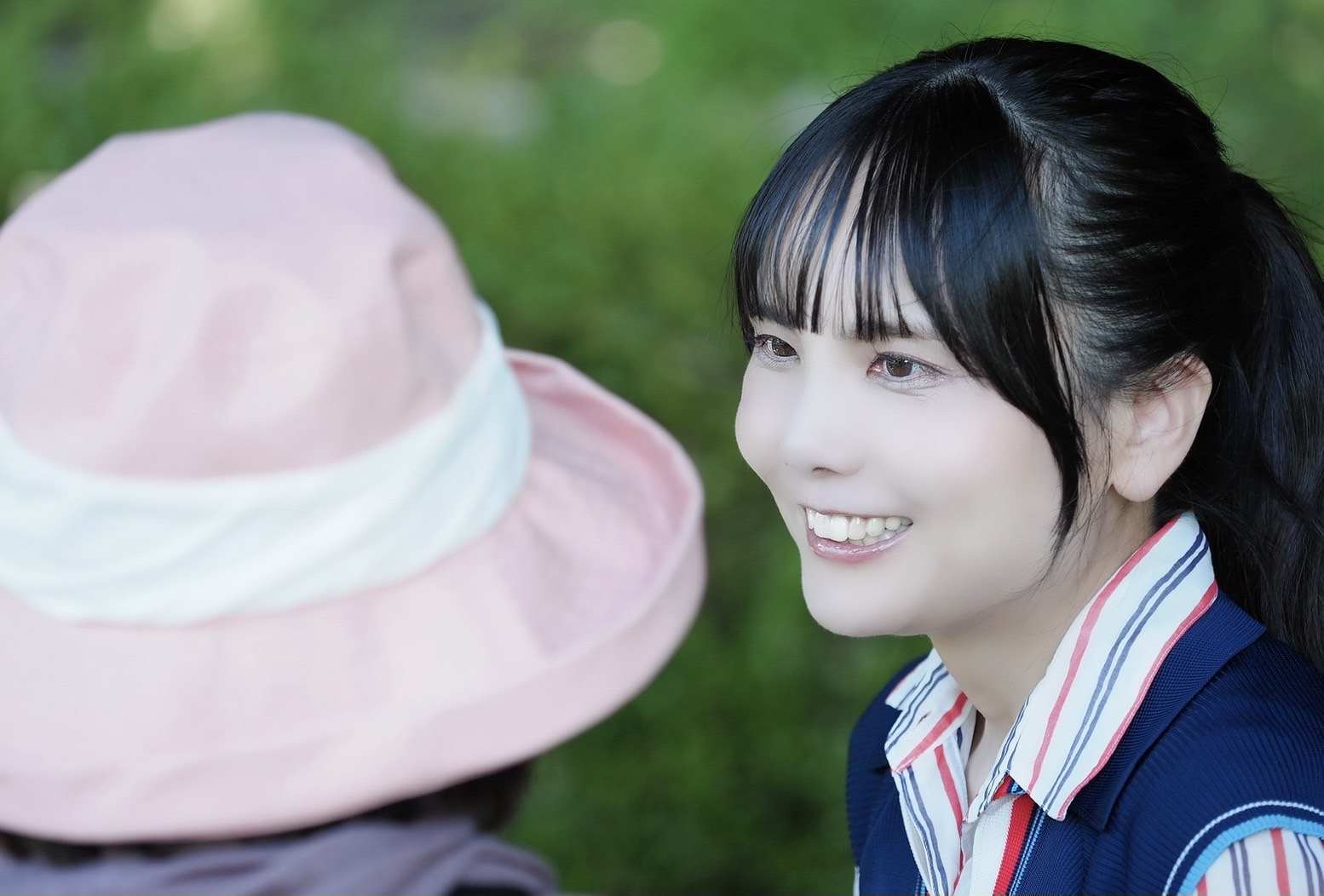 屋外で、帽子をかぶった方と笑顔で向き合う藤林あみ