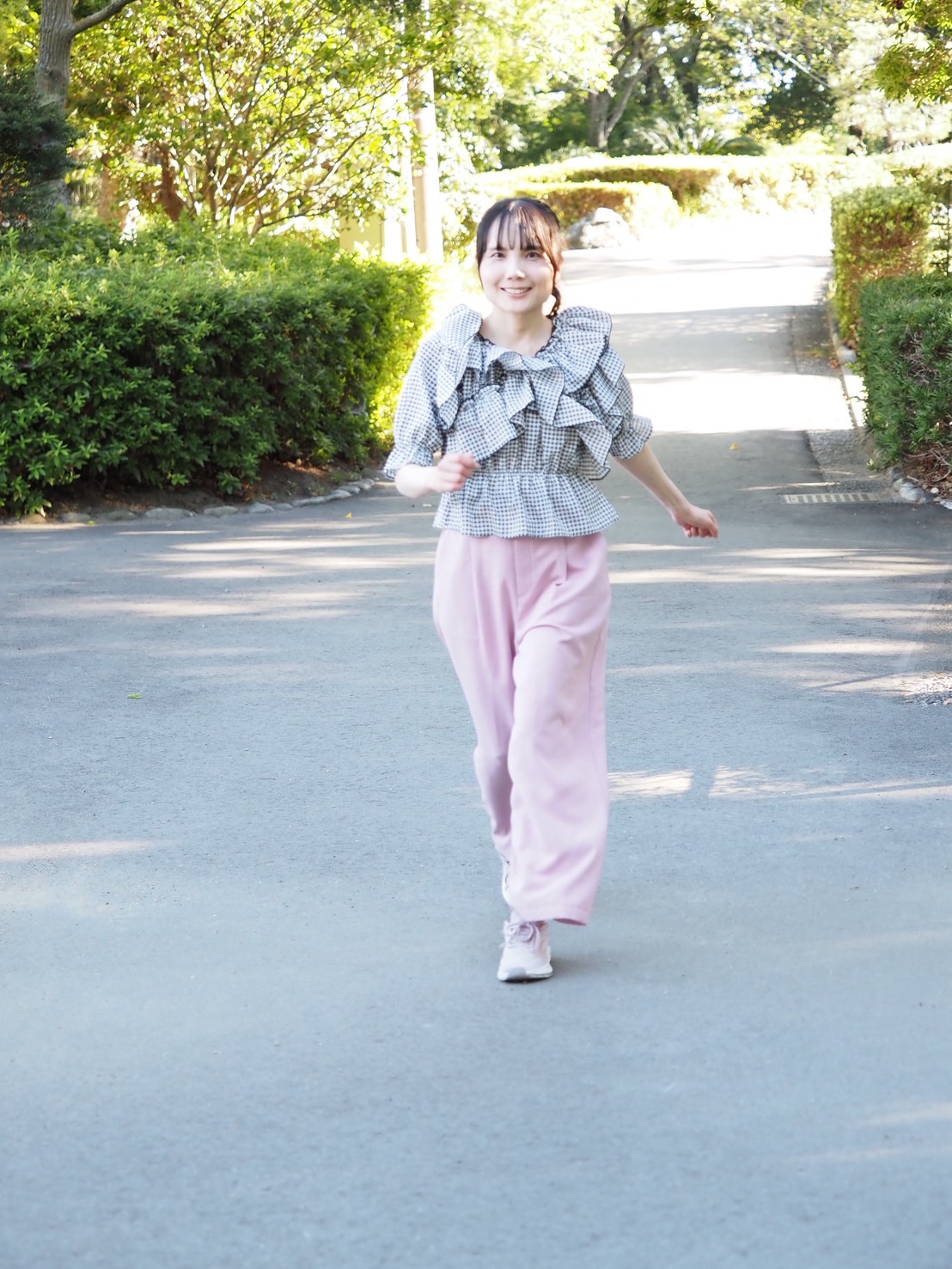 木々に囲まれた公園の道を歩く藤林あみ